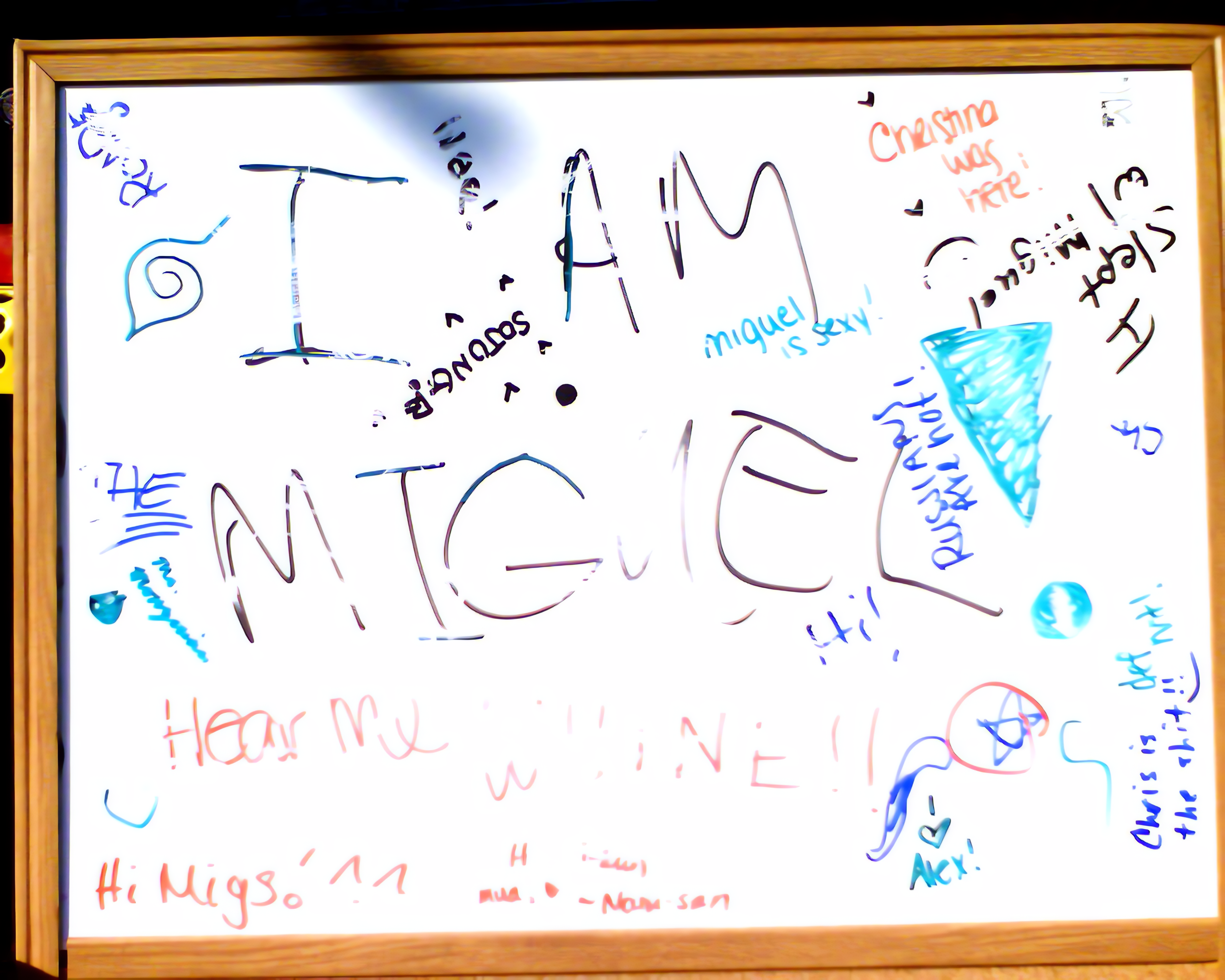 a white board with names and words written around the words I AM MIGUEL!