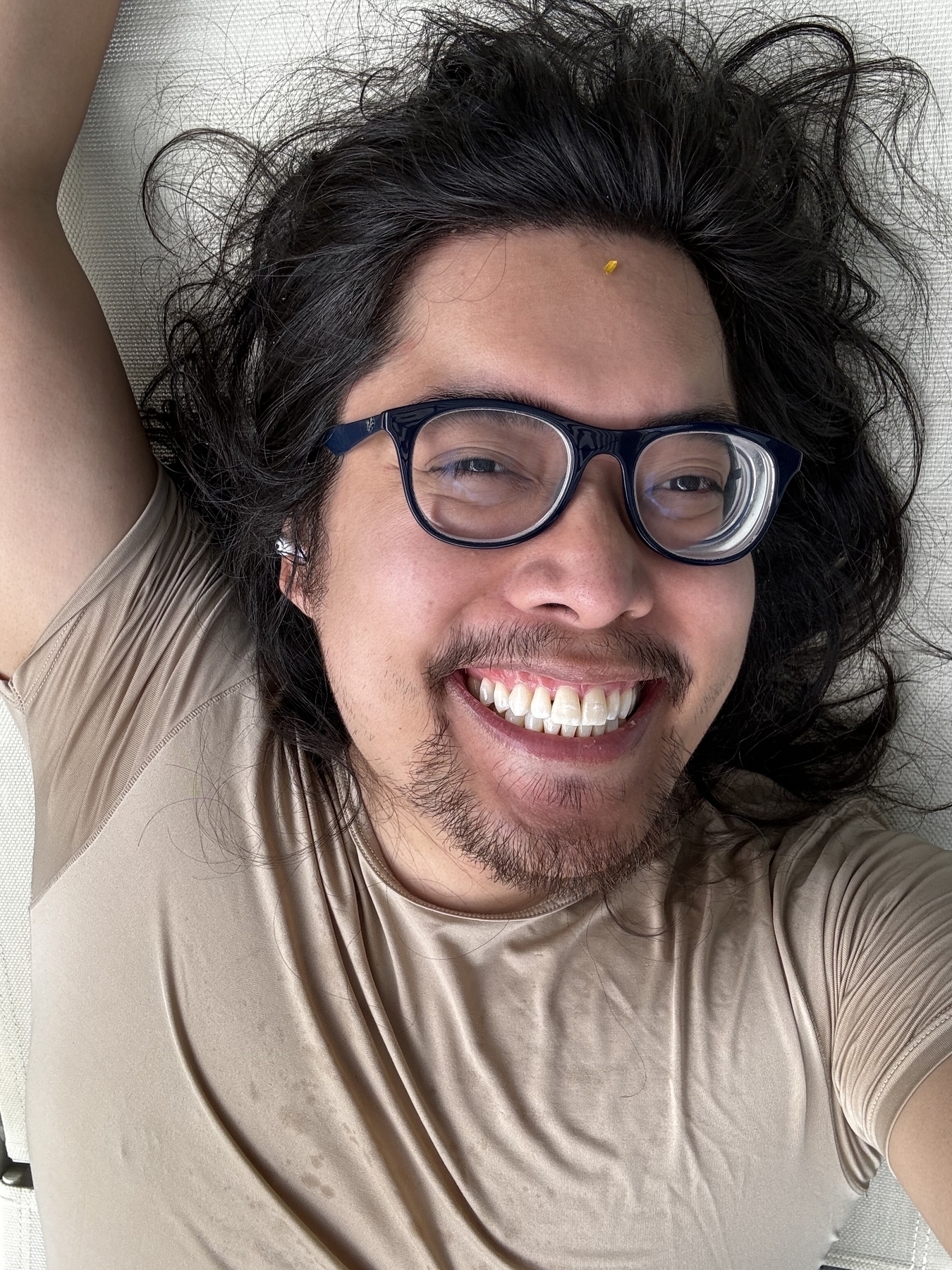 Miguel a masc Filipino man with black hair is looking at the camera with glasses. Yes smiling