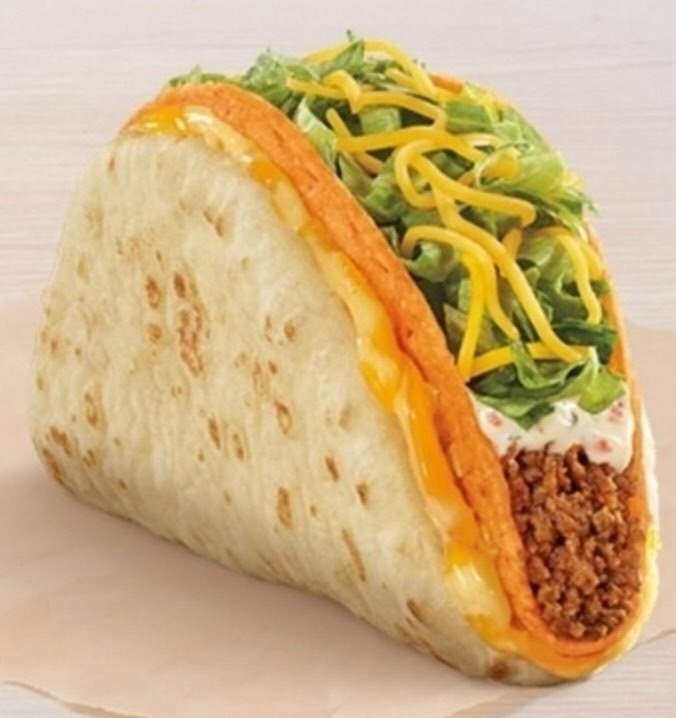 A folded and toasted flatbread taco with seasoned beef, lettuce, cheese, and creamy sauce.