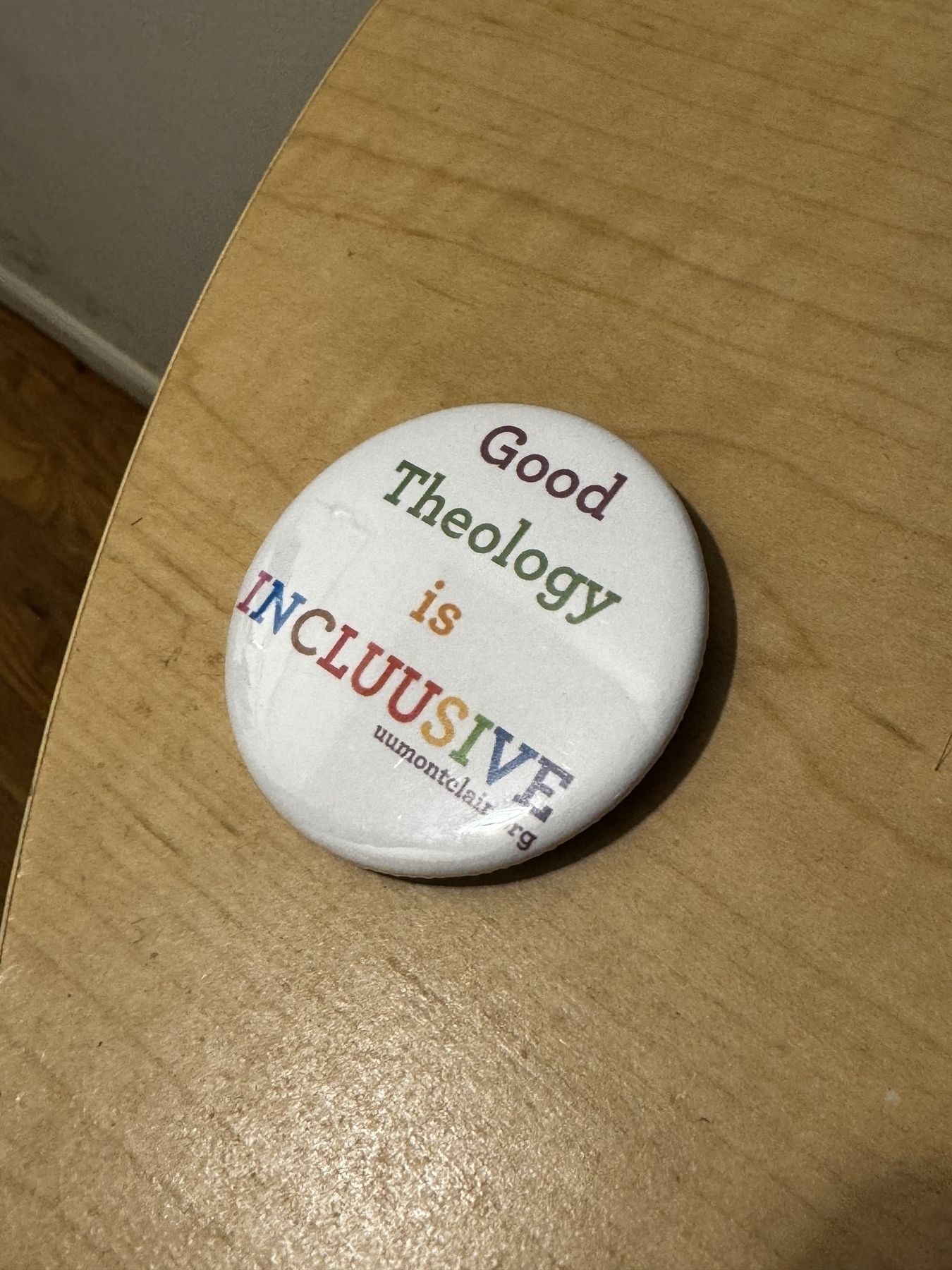  A white button with the words \"Good Theology is INCLUSIVE\" in rainbow letters.