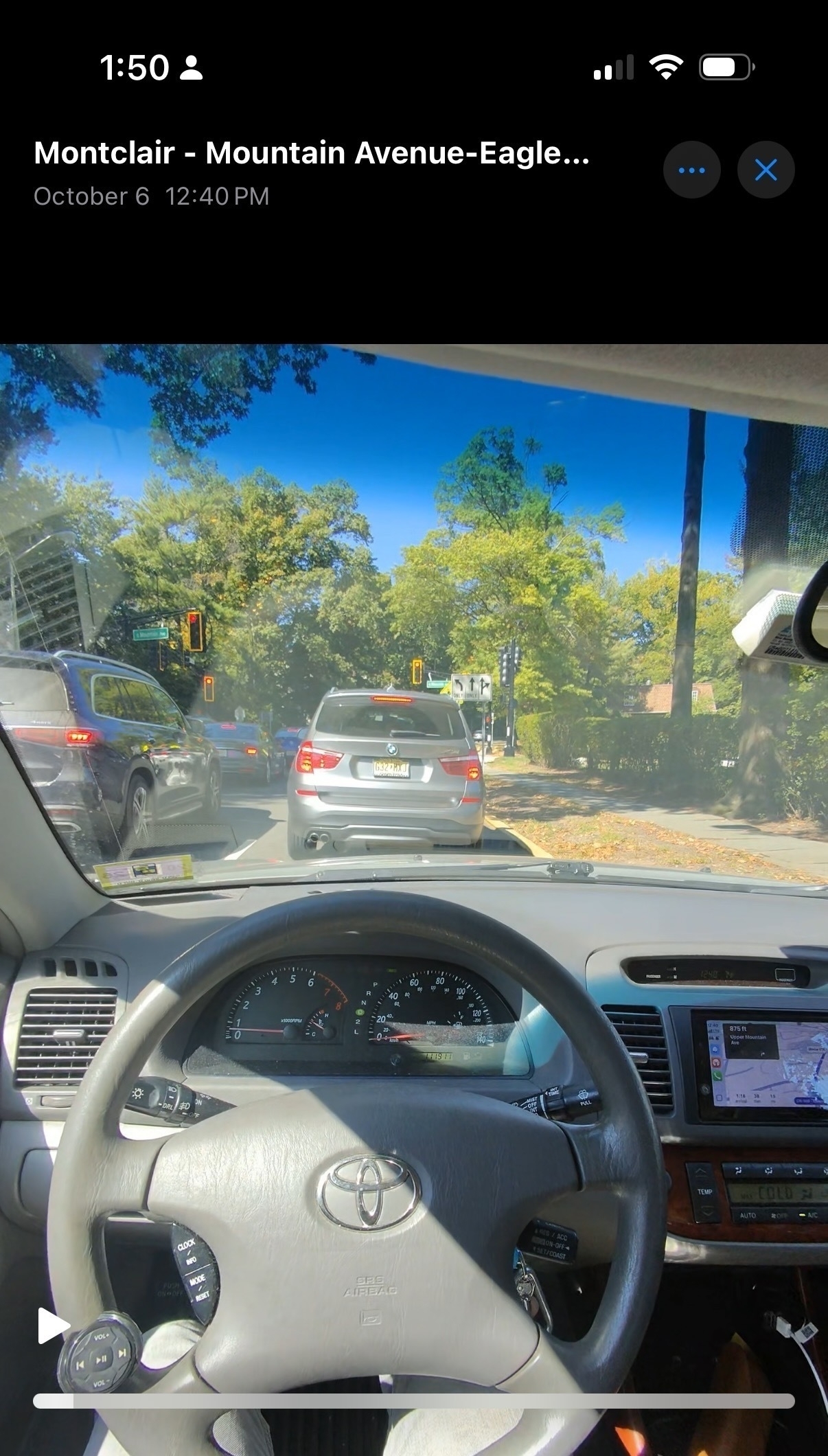 Photo taken from the driver’s seat showing a view of traffic ahead, with the dashboard, steering wheel, and center console visible, taken on October 6 at 12:40 PM.